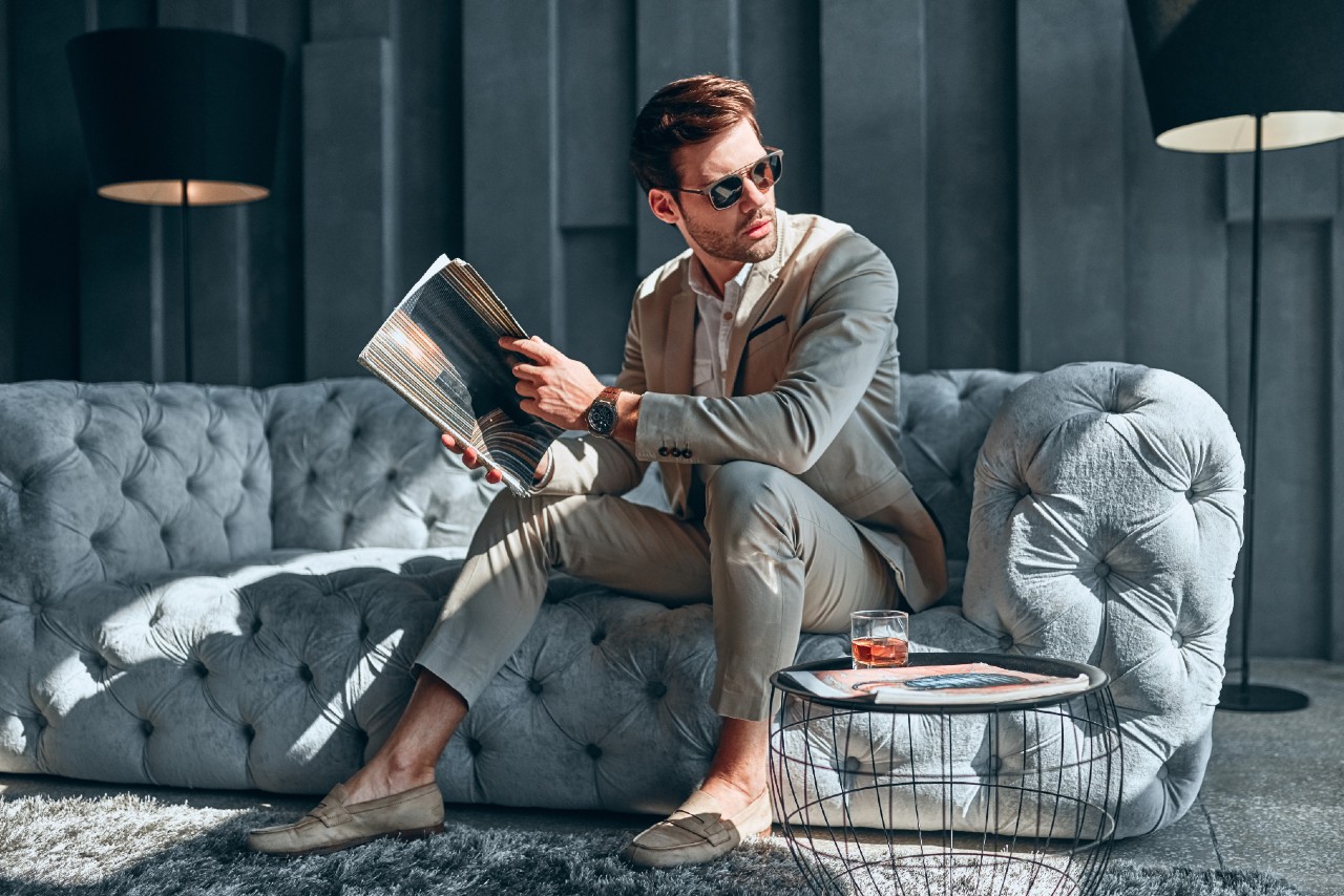 man looking at magazine with watch