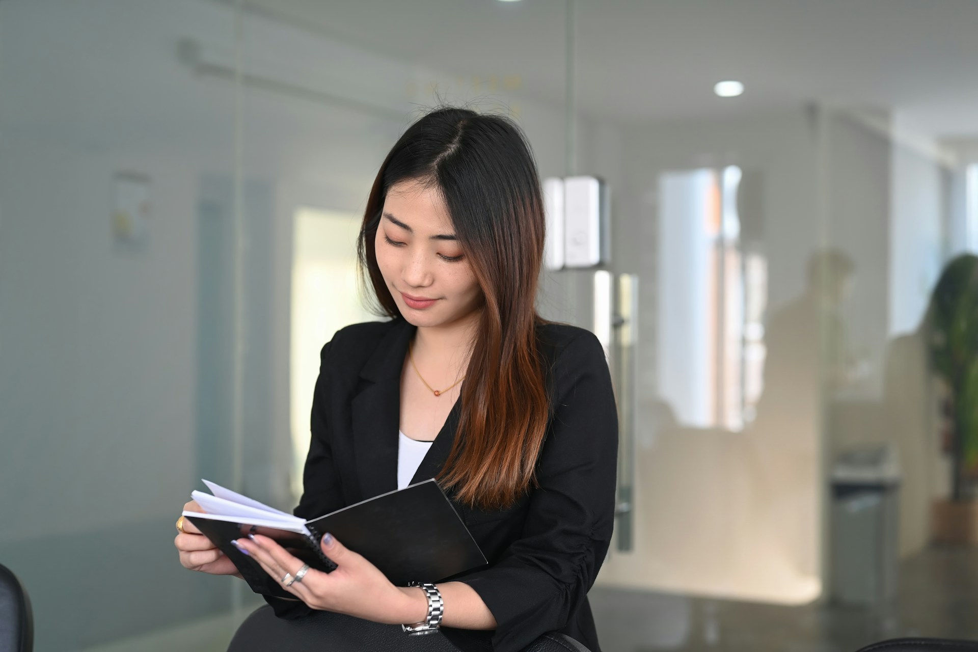 a lady holding a book and wearing a luxury timepiece