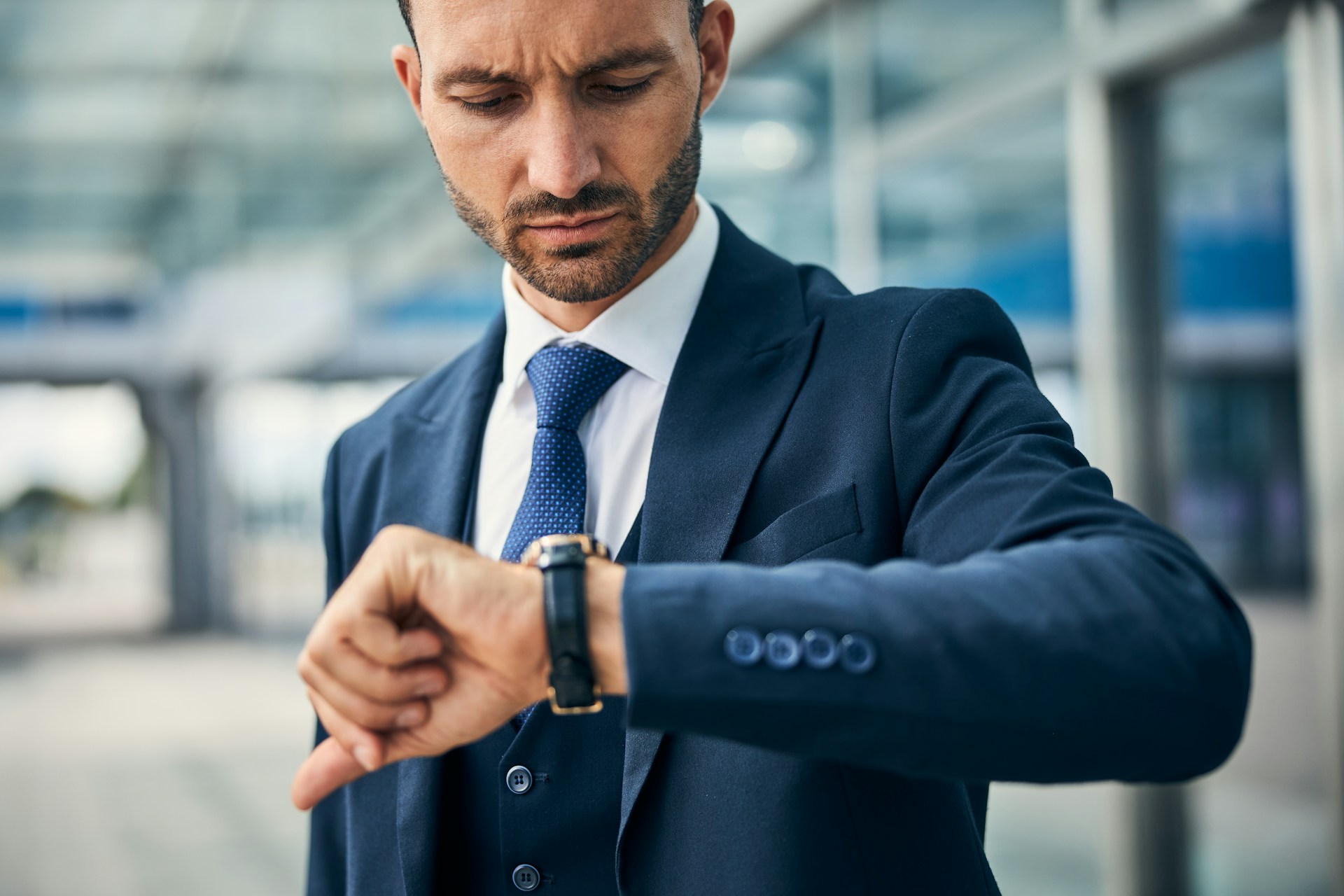 a man wearing a suit and looking at his watch