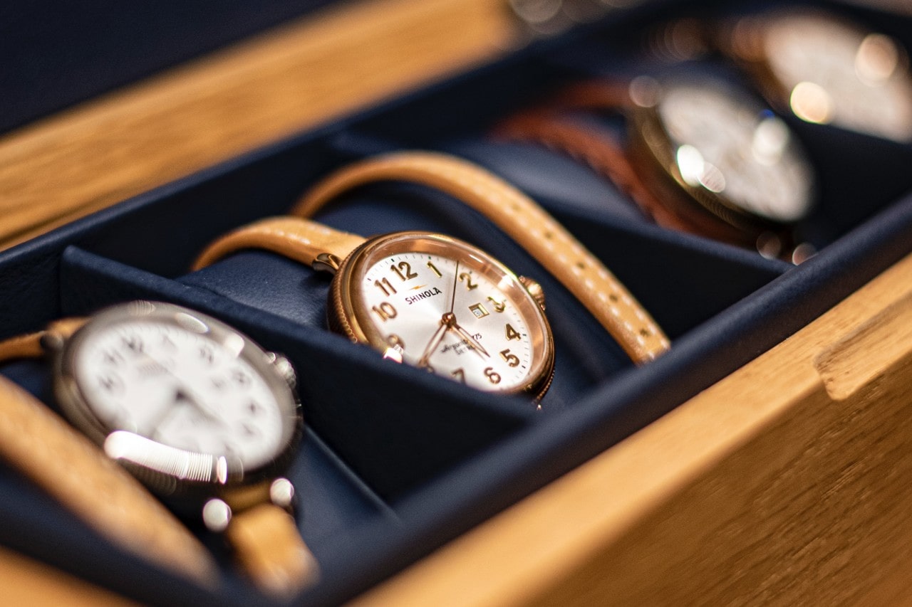 A close-up of an elegant watch case, displaying four luxury watches.