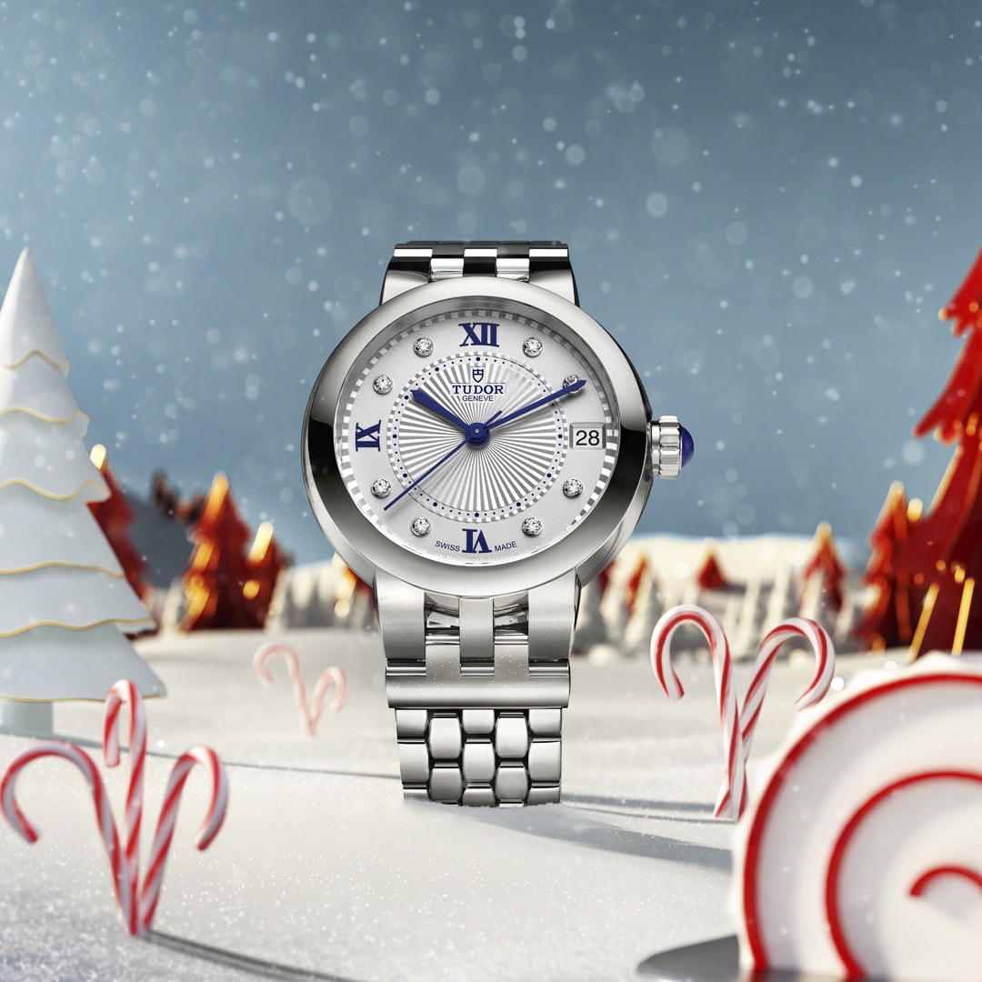 A close-up of a TUDOR Clair de Rose watch on a festive backdrop.